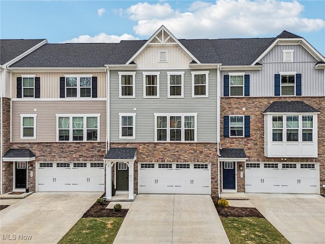 townhome / multi-family property featuring a garage, driveway, and board and batten siding