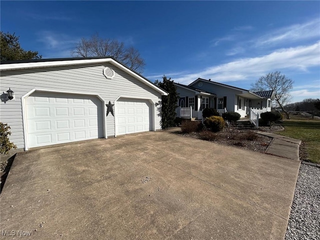 view of side of home featuring covered porch and concrete driveway