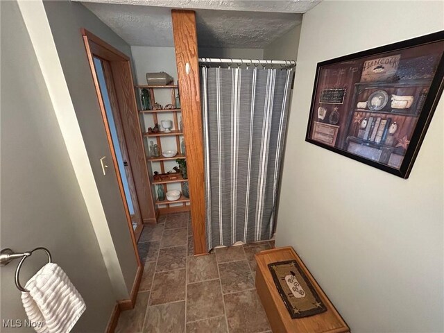 bathroom with a textured ceiling and baseboards