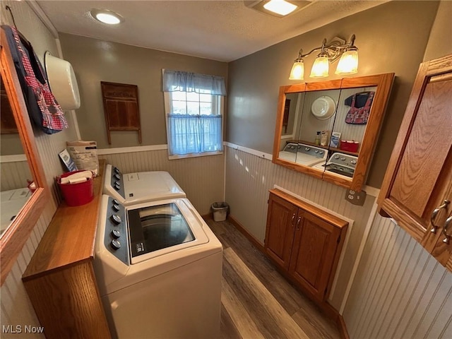 laundry room with a wainscoted wall, laundry area, wood finished floors, and washer / dryer