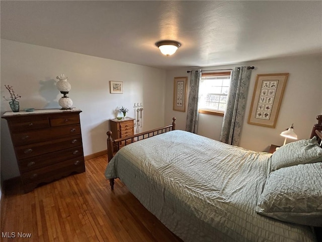 bedroom with baseboards and hardwood / wood-style flooring