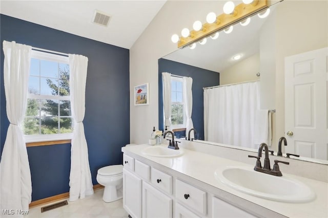 bathroom with lofted ceiling, visible vents, and a sink