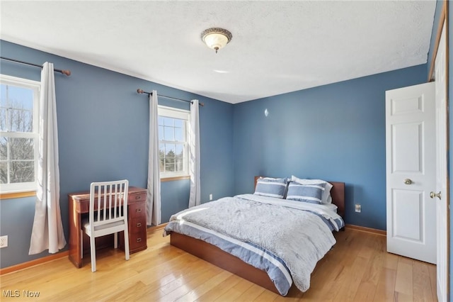 bedroom featuring wood finished floors and baseboards