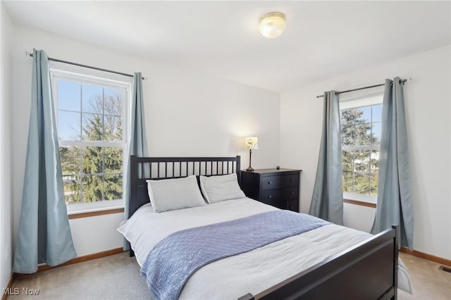 carpeted bedroom featuring visible vents, multiple windows, and baseboards