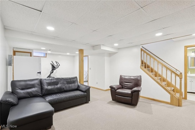 carpeted living room with stairway, baseboards, a drop ceiling, and recessed lighting