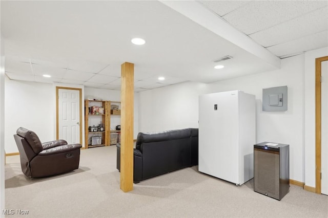 living room with a drop ceiling, recessed lighting, light colored carpet, visible vents, and electric panel