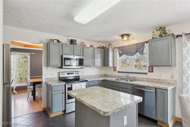 kitchen featuring appliances with stainless steel finishes, gray cabinets, and a sink