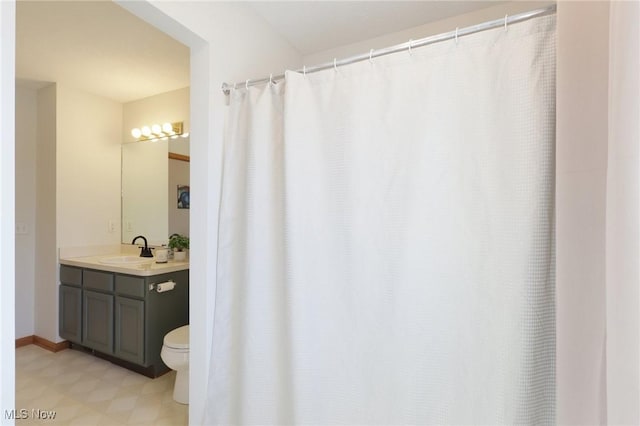 bathroom featuring vanity, toilet, and baseboards