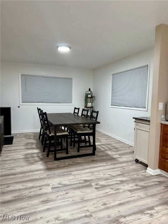 dining room with baseboards and light wood finished floors