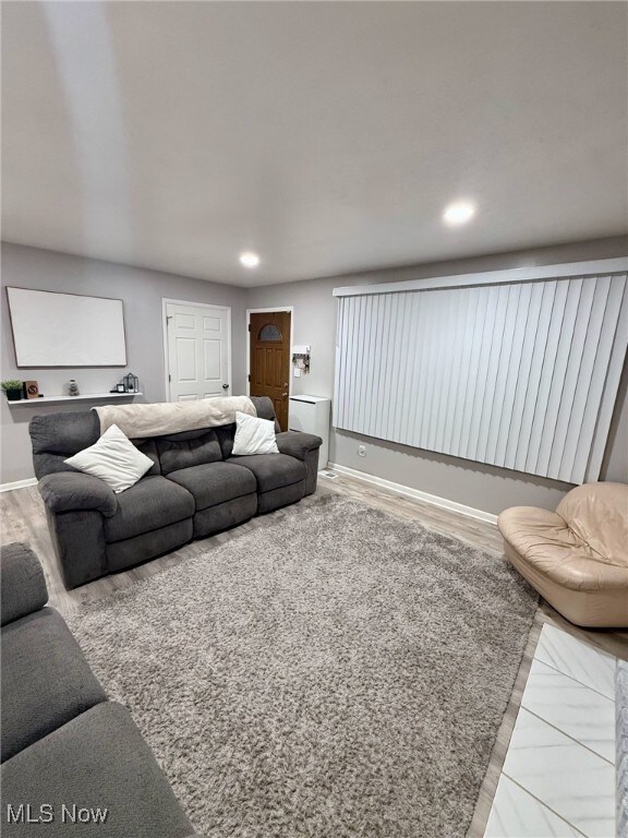 living area featuring baseboards and recessed lighting