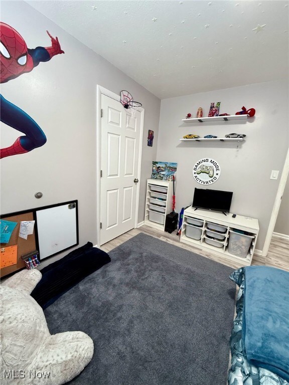 game room with baseboards and wood finished floors