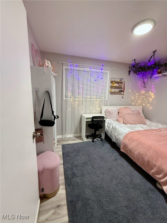 bedroom with wood finished floors and baseboards