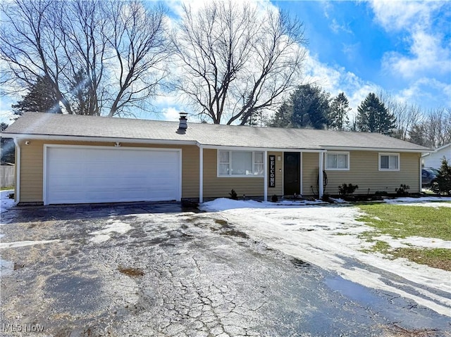 ranch-style home with a garage and aphalt driveway