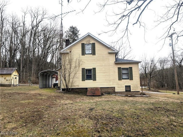 view of property exterior featuring a detached carport, a yard, and a chimney