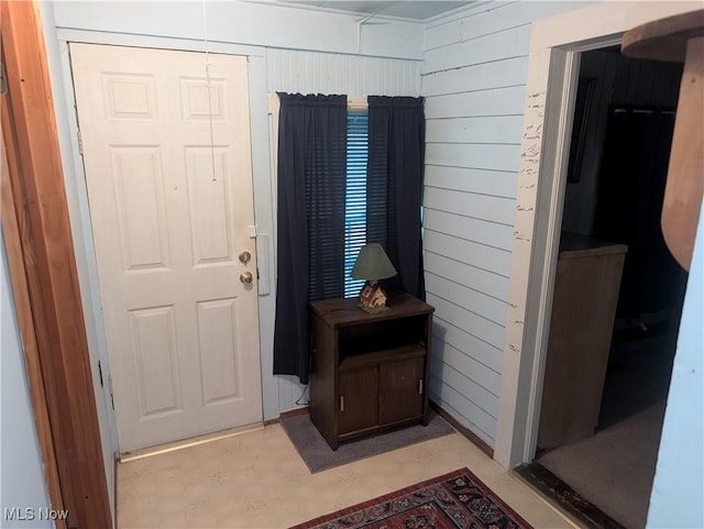 entryway featuring wood walls