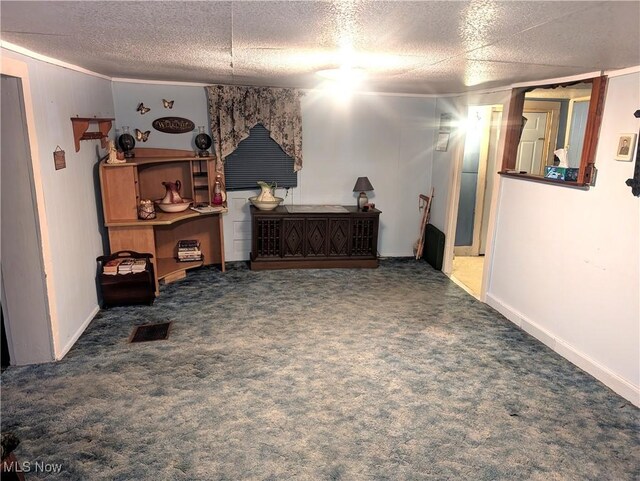 interior space with a textured ceiling, carpet, and visible vents