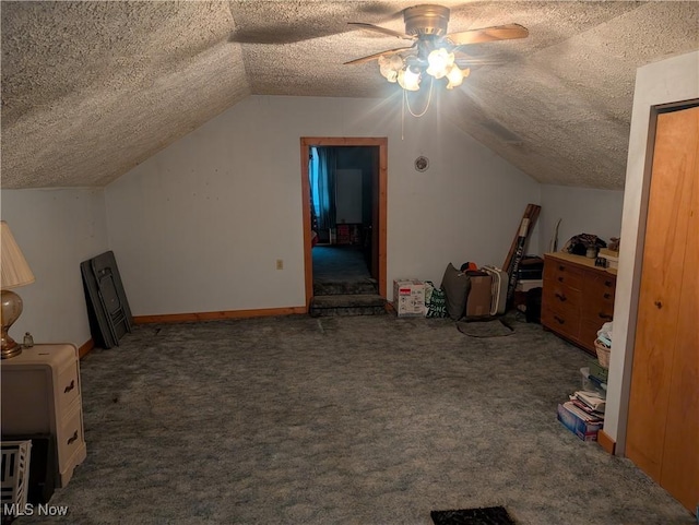 bonus room with baseboards, lofted ceiling, ceiling fan, a textured ceiling, and carpet floors