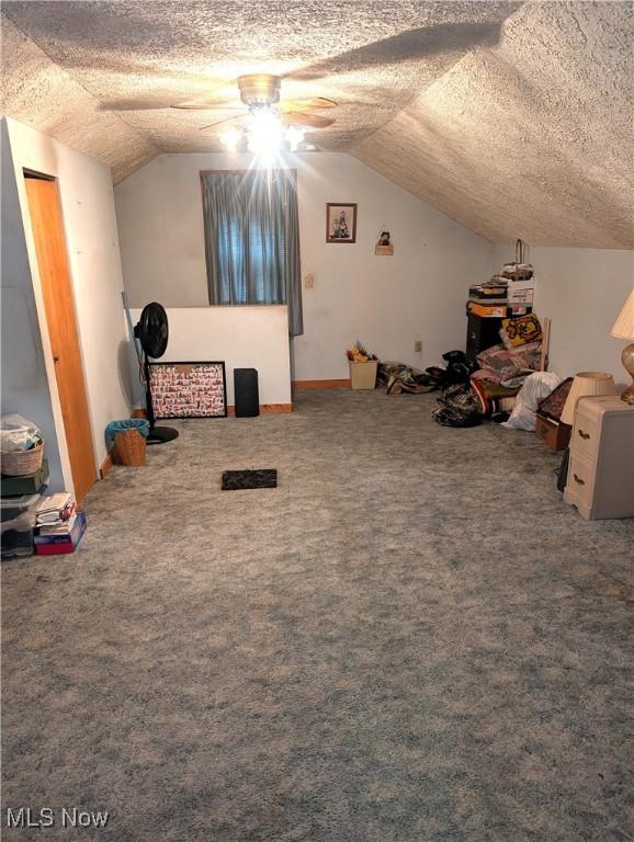 bonus room with carpet, vaulted ceiling, and a textured ceiling