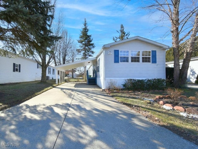 view of front of home featuring entry steps, concrete driveway, and an attached carport