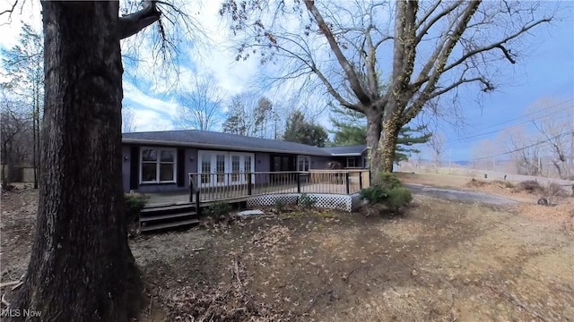 view of front facade featuring french doors and a wooden deck