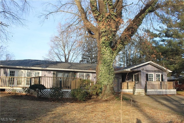 rear view of house with covered porch and a deck