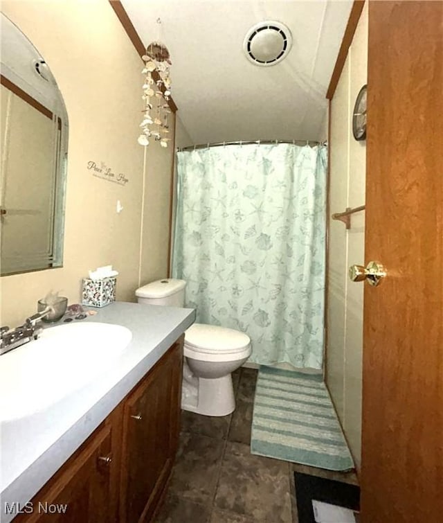 bathroom with toilet, curtained shower, tile patterned flooring, vaulted ceiling, and vanity