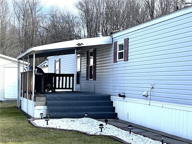 view of front of house with an outbuilding, a storage unit, and a front yard