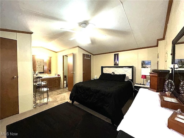 bedroom featuring connected bathroom, ornamental molding, vaulted ceiling, and a ceiling fan