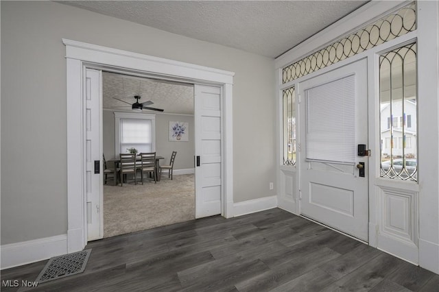 entrance foyer with baseboards, visible vents, dark wood-style flooring, and a textured ceiling