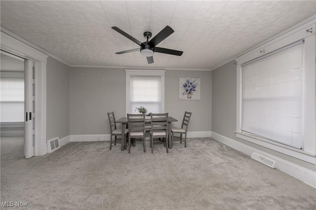 dining room with carpet floors, visible vents, ornamental molding, and baseboards