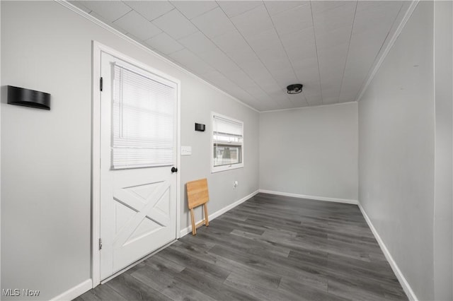 unfurnished room with dark wood-style flooring, crown molding, and baseboards