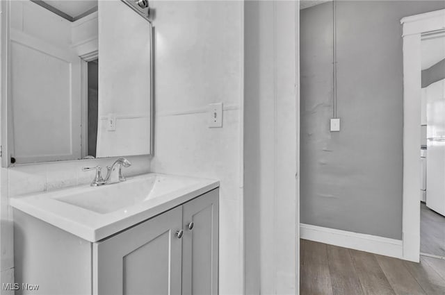 bathroom featuring wood finished floors, vanity, and baseboards