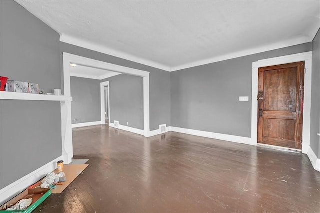 unfurnished living room featuring visible vents and baseboards