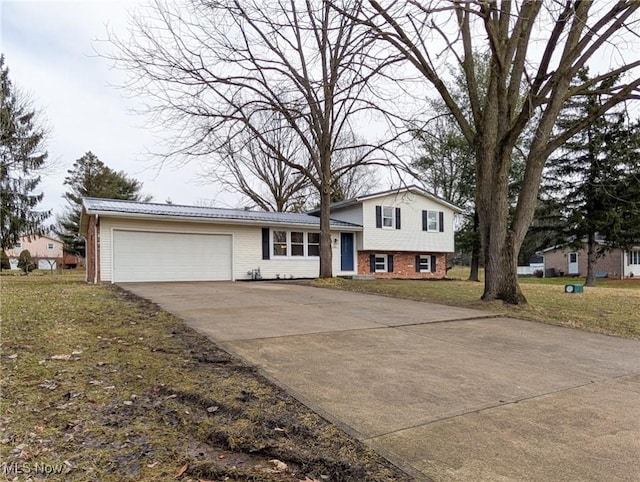 split level home with a garage, a front yard, brick siding, and driveway