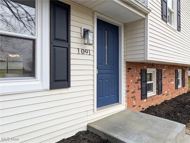 doorway to property with brick siding