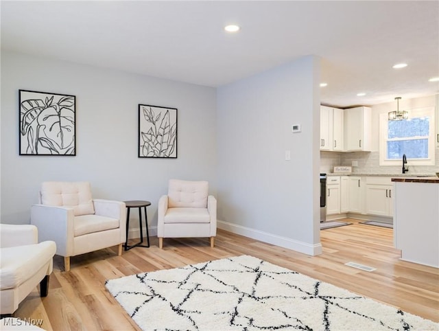 sitting room featuring light wood finished floors, recessed lighting, visible vents, and baseboards