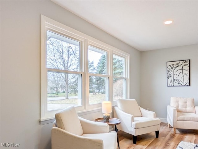 sitting room featuring light wood-type flooring, baseboards, a wealth of natural light, and recessed lighting