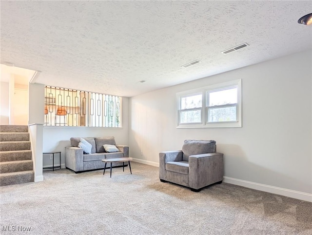 living area with stairs, visible vents, and carpet flooring