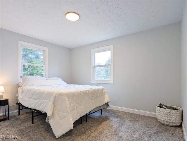 carpeted bedroom with baseboards and a textured ceiling