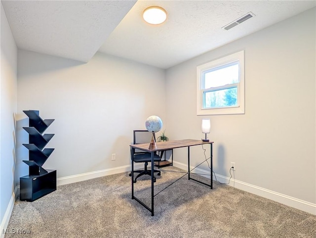 carpeted home office with a textured ceiling, visible vents, and baseboards