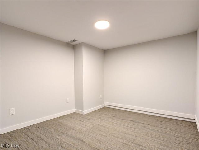 unfurnished room with baseboards and visible vents