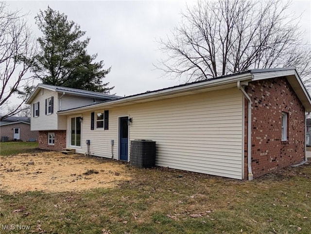 view of side of property with brick siding and central AC unit