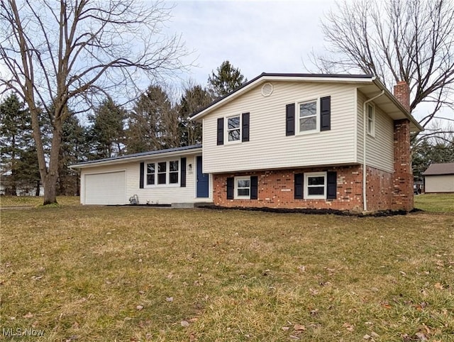 split level home featuring a front lawn, brick siding, a chimney, and an attached garage