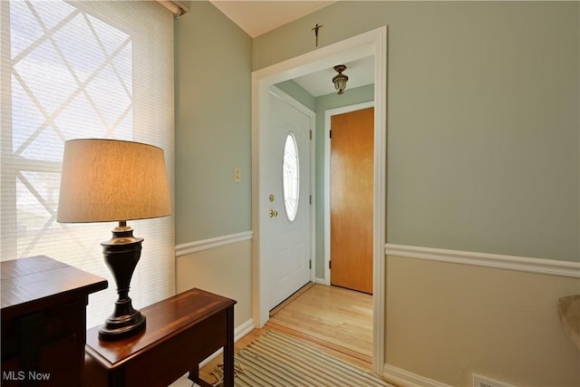 foyer entrance with baseboards and wood finished floors