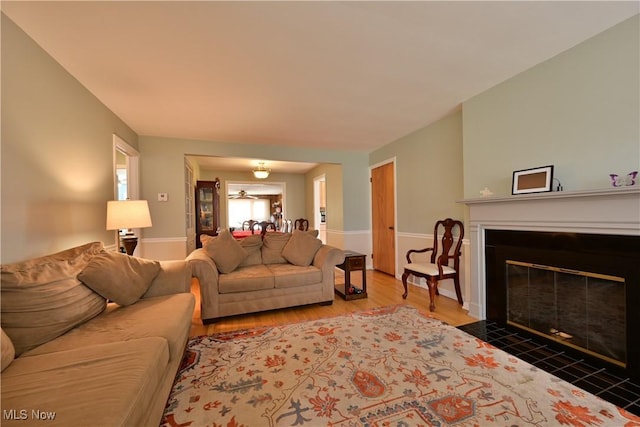 living area with a fireplace with flush hearth and wood finished floors