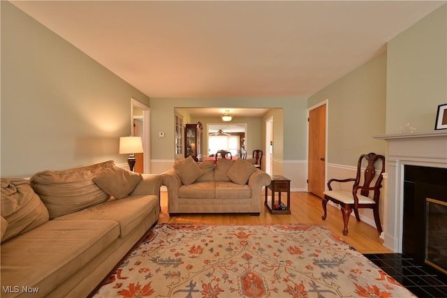 living area featuring a fireplace with flush hearth and wood finished floors