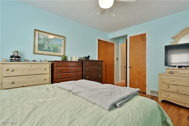 bedroom with visible vents, ceiling fan, and wood finished floors