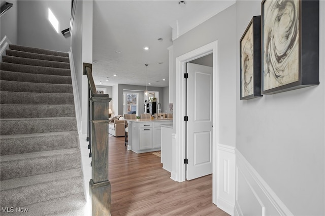 interior space featuring a wainscoted wall, wood finished floors, and recessed lighting