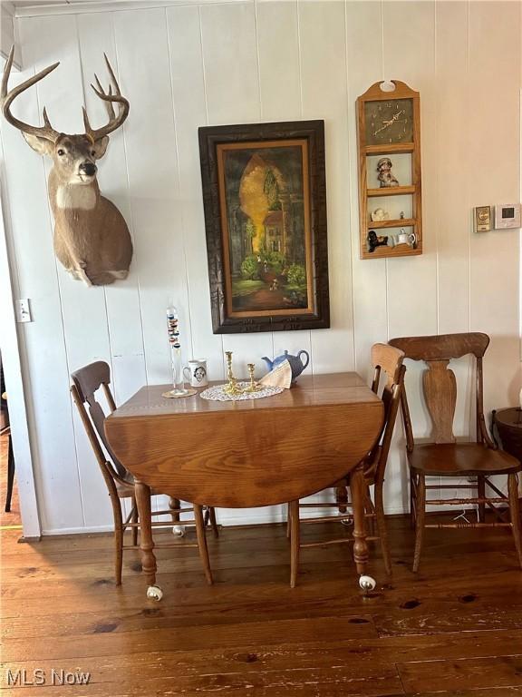 dining area with hardwood / wood-style flooring and a decorative wall