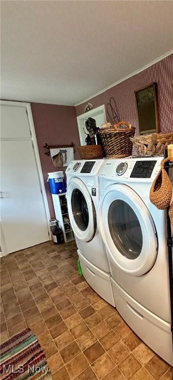 washroom with laundry area, washing machine and dryer, and wallpapered walls